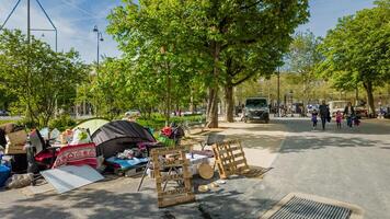 Vagabundo campamento en París, Francia, exhibiendo urbano pobreza y alojamiento crisis en medio de peatones en un soleado abril 14, 2024, con carpas y hecho a mano señales foto