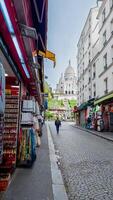 Cobblestone street lined with souvenir shops leading to the iconic Sacre Coeur Basilica in Montmartre, Paris, symbolizing French tourism and European travel photo