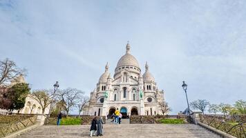 Tourists ascending the steps towards the Sacre Cur Basilica in Montmartre, Paris, on a clear day, ideal for travel and European heritage themes photo