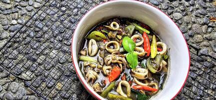 ndonesian home cooking menu, sauteed squid with black ink sauce with spicy seasoning called Tumis Cumi Hitam, including chili, ginger, and lime leaf photo