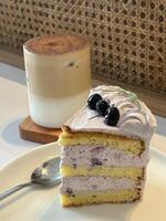 slice of blueberry cake decorated with fresh berries on white plate, delicious layered cake, top view photo