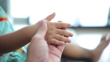 langzaam beweging, detailopname van een vader hand- Holding zijn zoon's hand. video