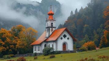 sereno Iglesia en medio de otoño colores y brumoso montañas foto