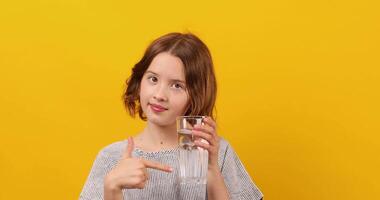 bonito adolescente chica, niño con un Fresco vaso de agua, video