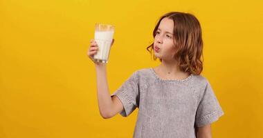 Pretty teen girl, child with a fresh glass of milk isolated video