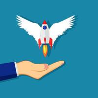 a hand holding a rocket with wings on it vector