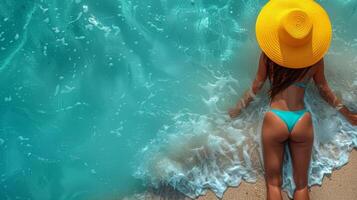 Woman in Bikini Sunbathing at Tropical Beach with Yellow Hat photo