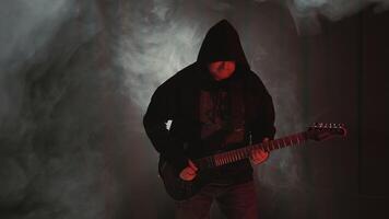 Silhouette of a guitarist on a dark stage with smoke playing rock. Playing the electric guitar. Rock guitarist on stage video