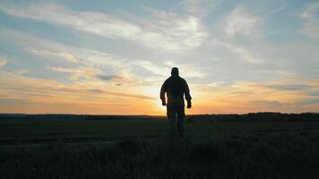 soldado de el ucranio ejército, un solitario soldados silueta en contra un vívido puesta de sol cielo en un abierto campo. video