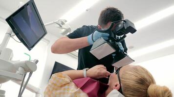 fotograferen de tandheelkundig kaak van een geduldig in een tandheelkundig kliniek. een tandarts duurt een afbeelding van een patiënten tanden. video