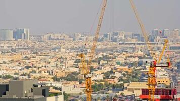 Urbain construction grues plus de Dubai paysage urbain, la tour grues imposant plus de Dubai, mettant en valeur le dynamique Urbain développement et architectural croissance. video