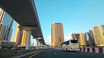 vae, Dubai - Verenigde Arabisch emiraten 01 april 2024 dynamisch stedelijk snelweg tafereel met modern wolkenkrabbers, visie van een snelweg in een bruisend stad met modern wolkenkrabbers en infrastructuur gedurende een zonnig video