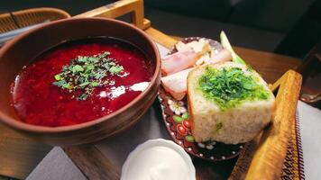 traditionell ukrainisch Gericht Borscht im ein Keramik Topf mit Donuts video