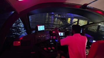 uae, dubai - Unidos árabe Emirados 01 abril 2024 período noturno barco passeio dentro dubai com capitão às a leme, interior Visão do uma barco cockpit durante uma noite passeio dentro dubai, apresentando a capitão navegação video
