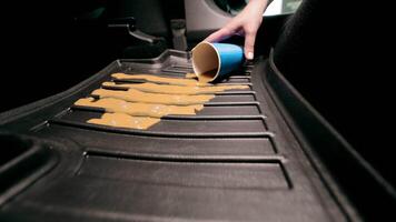 verschüttet Kaffee auf das Teppich im das Wagen. Verschmutzung von das Auto im das Kabine. ein Blau Einweg Tasse mit Kaffee Stürze auf das Auto Fußboden Matte video