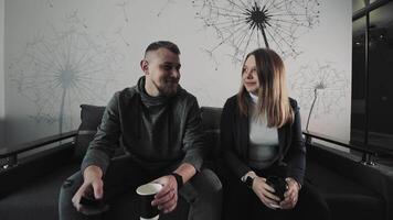 souriant couple avec café sur canapé, une content couple actions une lumière moment avec café sur une moderne canapé. video