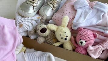 baby en kind kleren en gebreid speelgoed in karton doos. video