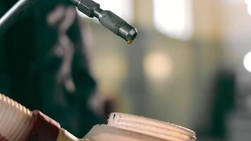 Pouring lubricant into the canister. A craftsman pours car oil into a canister, close-up. video