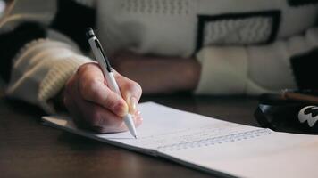 A woman makes notes with a pen in a notebook during a lecture, close-up. video