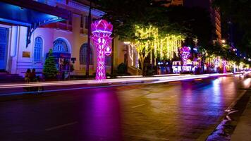 ein Nacht Zeitraffer von Neon- Stadt, Dorf beim nguyen Farbton Straße im ho Chi minh breit Schuss Schwenken video