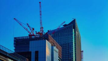 A timelapse of cranes at the under construction behind the blue sky in Tokyo video