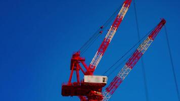 A timelapse of cranes at the under construction behind the blue sky in Tokyo video