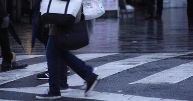 a piedi persone corpo parti a il attraversamento nel Shinjuku tokyo piovoso giorno video