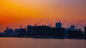 une temps laps de en mouvement grues à le baie zone dans tokyo à crépuscule large coup video