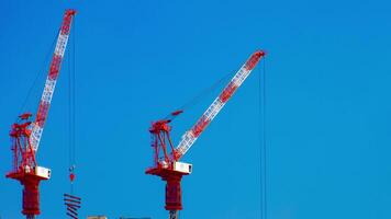 A timelapse of cranes at the under construction behind the blue sky in Tokyo video