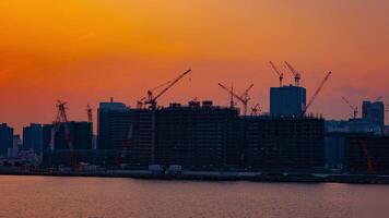 A time lapse of moving cranes at the bay area in Tokyo at dusk wide shot video