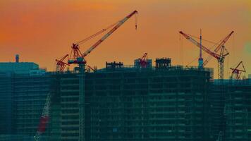 A time lapse of moving cranes at the under construction in Tokyo at dusk video