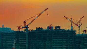 A time lapse of moving cranes at the under construction in Tokyo at dusk video