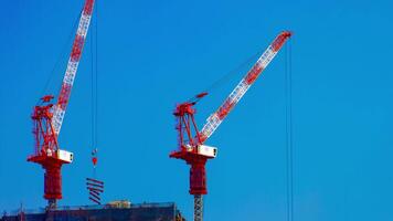 A timelapse of cranes at the under construction behind the blue sky in Tokyo video