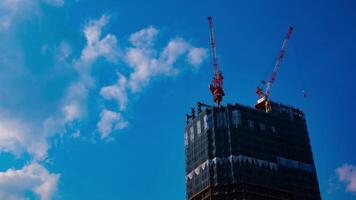 uma espaço de tempo do guindastes às a debaixo construção atrás a azul céu dentro Tóquio video