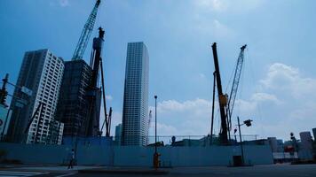 A timelapse of moving cranes at the under construction in Tokyo wide shot zoom video