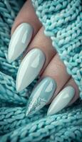 Feminine hand with white nail art, glitter manicure, and pastel sweater in stylish frame photo