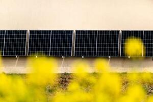 solar paneles en un bien expuesto pared de un individual casa, haciendo ahorros siguiendo el energía crisis, ciudadano ecológico gesto, verde energía foto