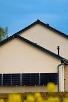 solar paneles en un bien expuesto pared de un individual casa, haciendo ahorros siguiendo el energía crisis, ciudadano ecológico gesto, verde energía foto