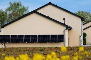 solar paneles en un bien expuesto pared de un individual casa, haciendo ahorros siguiendo el energía crisis, ciudadano ecológico gesto, verde energía foto