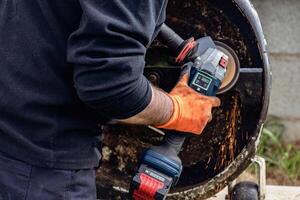 Man using portable grinder with sparkles photo