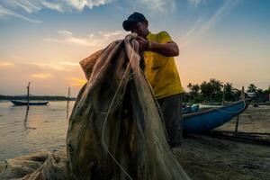 Traditional fishermen and boats in O Loan lagoon during sunset, Phu Yen province, Vietnam. Travel and landscape concept photo