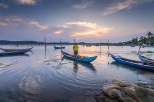 Traditional fishermen and boats in O Loan lagoon during sunset, Phu Yen province, Vietnam. Travel and landscape concept photo