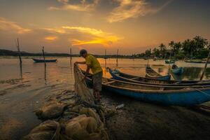 Traditional fishermen and boats in O Loan lagoon during sunset, Phu Yen province, Vietnam. Travel and landscape concept photo