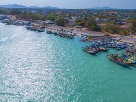 aéreo ver de loc un pescar aldea, vung tau ciudad. un pescar Puerto con tsunami proteccion hormigón bloques paisaje urbano y tradicional barcos en el mar. foto