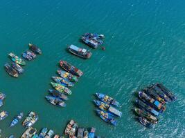 Aerial view of Loc An fishing village, Vung Tau city. A fishing port with tsunami protection concrete blocks. Cityscape and traditional boats in the sea. photo