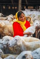 vietnamita mujer con Cordero en un campo, un oveja granja en el estepa zona en ninh Thuan provincia, Vietnam. foto