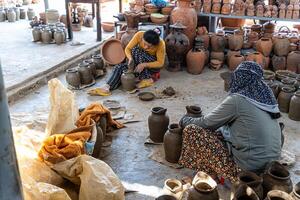 a pottery artist create traditional handicraft clay vase in Bau Truc pottery village. Using traditional techniques. photo