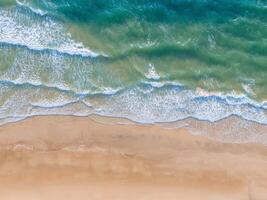 Oceano olas en el playa como un antecedentes. aéreo parte superior abajo ver de playa y mar con azul agua ondas. Vietnam playa foto