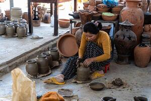 a pottery artist create traditional handicraft clay vase in Bau Truc pottery village. Using traditional techniques. photo