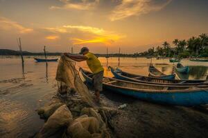 Traditional fishermen and boats in O Loan lagoon during sunset, Phu Yen province, Vietnam. Travel and landscape concept photo